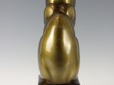 bronze sculpture of a cat sitting on top of a wooden base