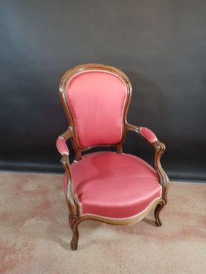 pair of pink chairs with gold trim and wooden arms