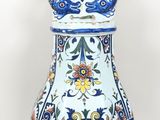 un vase bleu et blanc surmonté d'un éventail