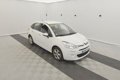 voiture blanche garée dans un garage dont le sol est à carreaux noirs et blancs