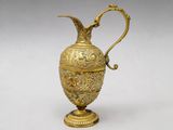 an ornate gold vase with a handle and a handle