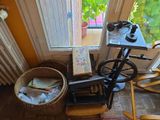 une machine à coudre posée devant une fenêtre, à côté d'une chaise