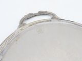 a silver plate with a handle on a white surface