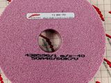 pink sanding disc on a piece of paper with a measuring tape