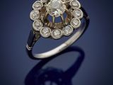 an old cut diamond ring with a center stone surrounded by small round diamonds
