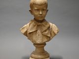 statue of a young boy with a bow tie on a pedestal