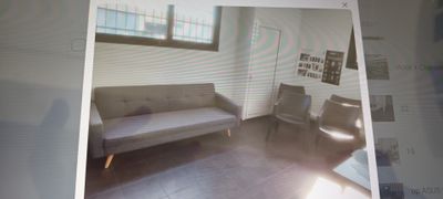 une photo d'un salon avec un canapé et un fauteuil