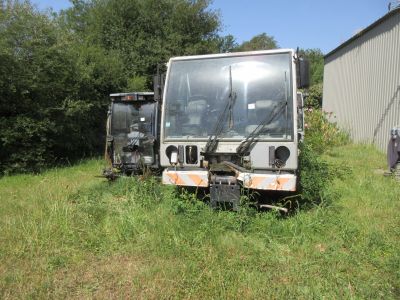 un camion garé dans l'herbe près d'un bâtiment