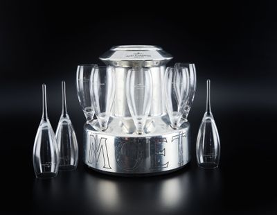 quatre verres à vin et un seau à vin en argent posés sur une table noire