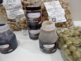 many different types of olives and sauces on the counter
