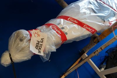 une peluche emballée dans du plastique et attachée à un poteau