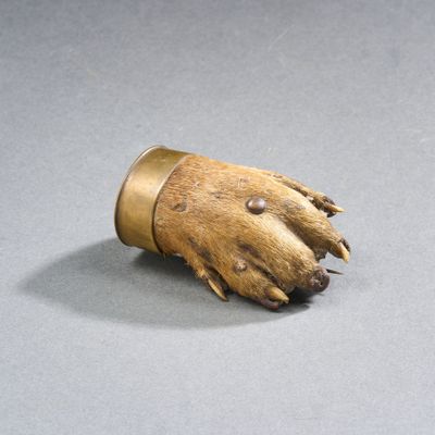 un petit objet en bois sur lequel est gravée une patte d'ours