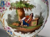 a vase with a picture of a woman sitting on a bench