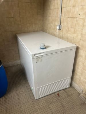 un petit réfrigérateur blanc dans un coin de la salle de bains
