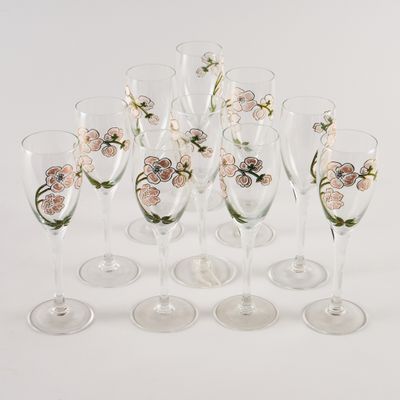 six verres à vin décorés de fleurs, posés sur une surface blanche