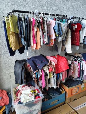 beaucoup de vêtements suspendus à une étagère dans une pièce