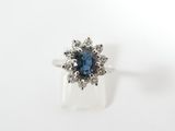 gros plan d'une bague en diamant bleu et blanc sur une surface blanche