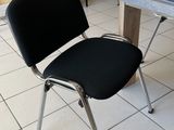 une chaise noire posée près d'une table dans une pièce