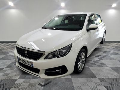 La voiture blanche est garée sur le sol à damier du garage.