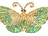 une image représentant une broche en forme de papillon ornée de pierres vertes et blanches
