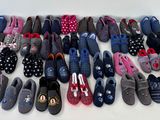 Plusieurs paires de chaussons sont alignées sur une surface blanche