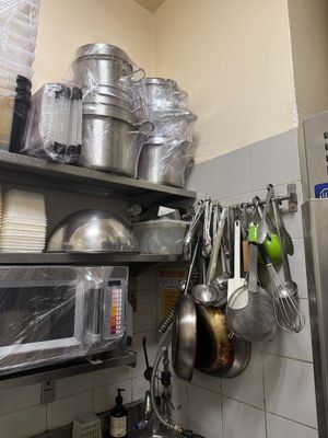 de nombreuses casseroles et poêles sur les étagères de la cuisine