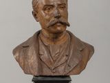 statue of a bust of a man with a mustache on a wooden table