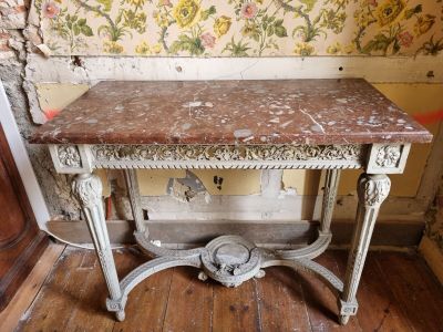 une petite table avec un plateau en marbre sur un plancher en bois