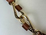 brown leather belt with a gold metal clasp on a mannequin torso