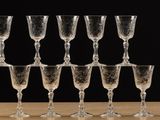 many wine glasses sitting on a table with a black background