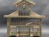 a small bird cage with a bell on top of it