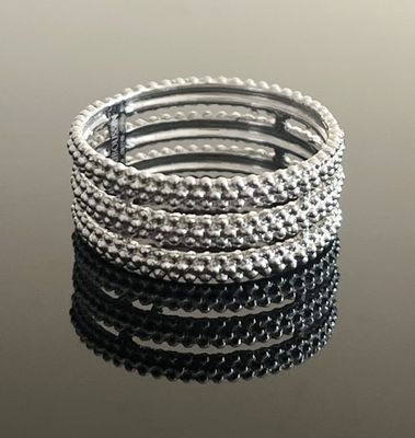 un gros plan sur une pile de bracelets en argent posés sur une table