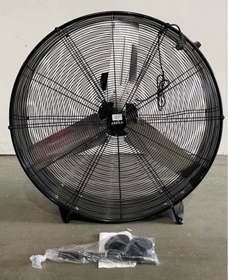 a fan that is sitting on the floor next to a bag