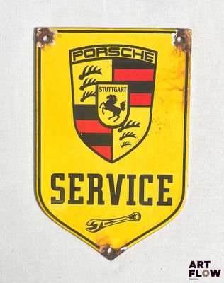 panneau « Porsche Service » jaune et noir accroché à un mur blanc