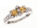 un gros plan d'une bague en diamant sertie de deux saphirs jaunes en forme de poire