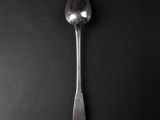 a silver spoon with a spoon handle on a black surface