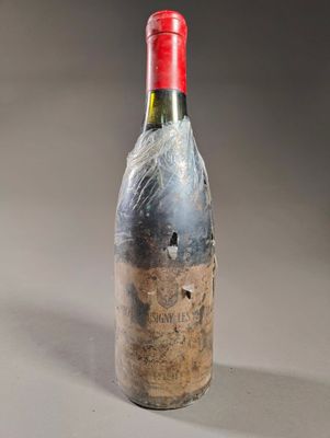 une vieille bouteille de vin est posée sur une table
