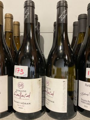plusieurs bouteilles de vin sont alignées sur une étagère