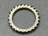 a close up of a black and gold bracelet on a gray surface