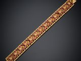 a gold bracelet with red and yellow designs