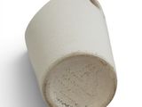 a close up of a white cup with a hole in it