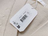 an image of a white sweater with a price tag attached to it