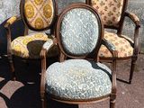 three chairs with floral upholstered cushions sit in front of a wall