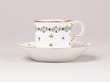 une tasse et une soucoupe ornées de fleurs et de feuilles