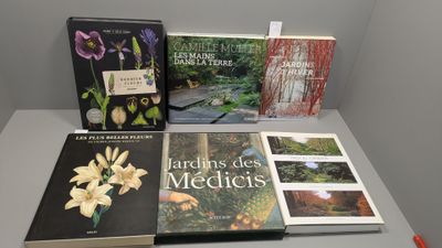 Plusieurs livres sont posés sur une table, à côté d'une paire de ciseaux.