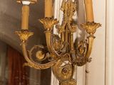 a gold chandelier hanging from a mirror in a room