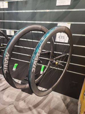 Trois vélos sont exposés dans un magasin de vélos : l'un est noir et l'autre est bleu.