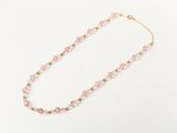 a pink beaded necklace on a white background