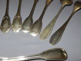 a lot of silver spoons and forks on the table