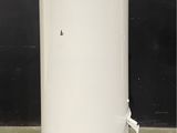 a white water heater sitting on top of a cement floor